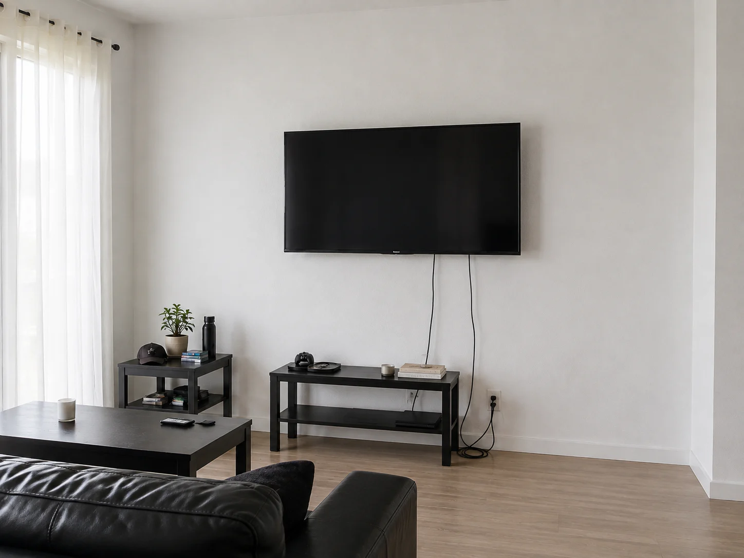 Entertainment wall before installation, with visible cables and temporary furniture.