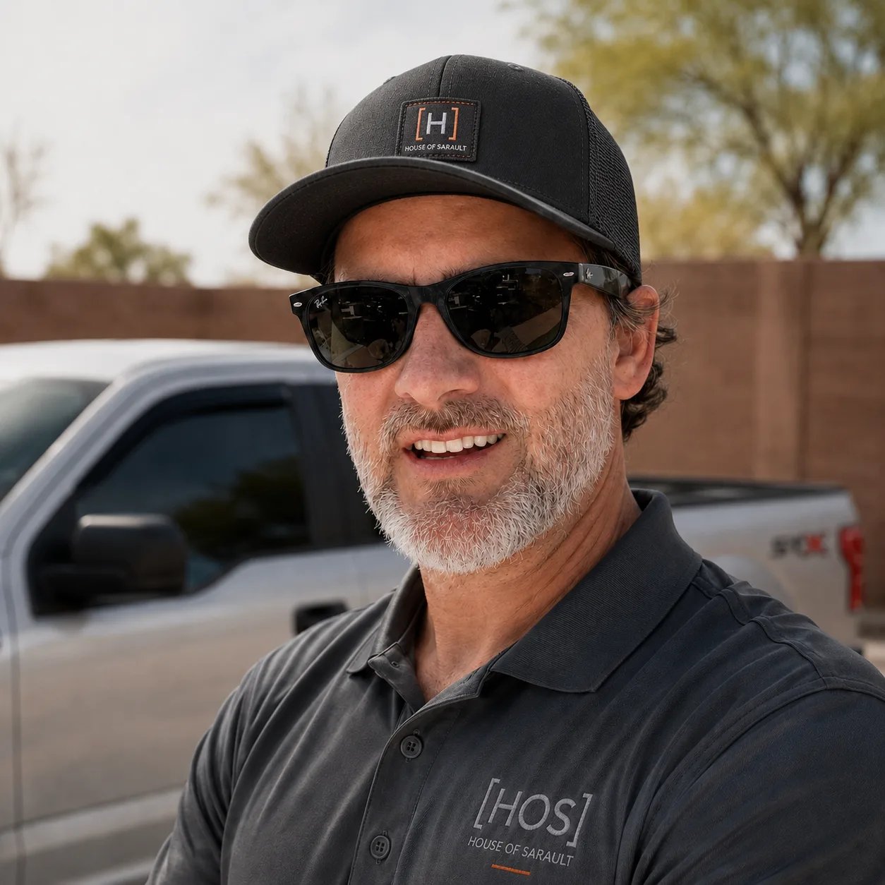 Kevin Sarault wearing House of Sarault workwear beside a branded work truck.